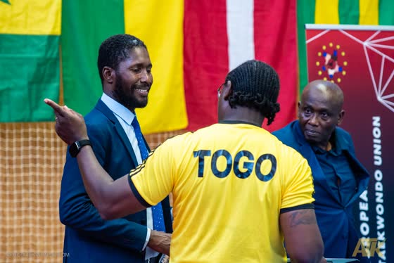 Encadrement togolais et officiels au pied du praticable — l’arbitre togolais Galé Tété Djramedo sera distingué parmi les quatre meilleurs du tournoi.